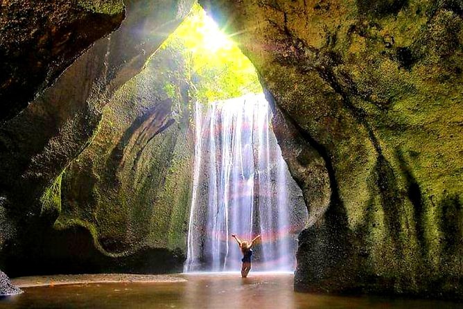 Light falling through the cave roof onto the Tukad Cepung waterfall in east Bali